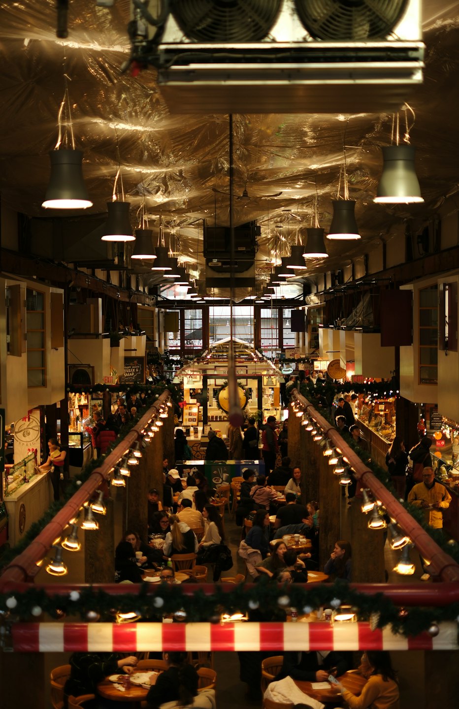 Persone che cenano e curiosano nei negozi in un vivace food hall.