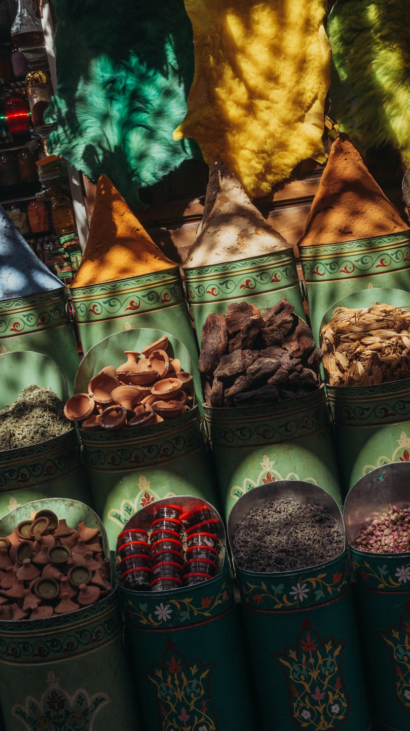 Mercato con cumuli di spezie colorate e ceramiche.